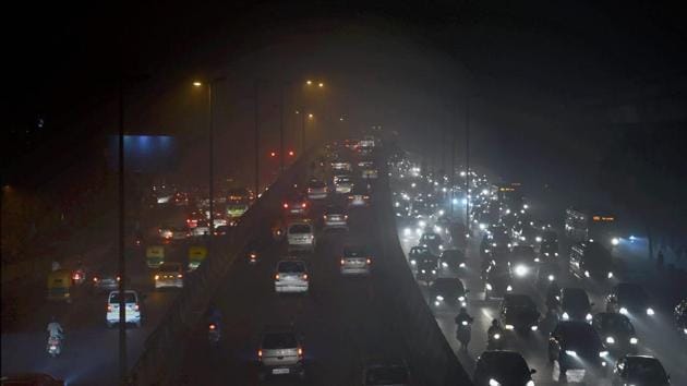 Vehicles ply at a slow pace near Punjabi Bagh due to low visibility caused by air pollution in New Delhi on Tuesday.(PTI)