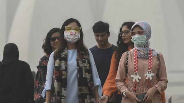 Tourists wear masks as they visit the Lotus Temple in New Delhi.(Burhaan Kinu/HT Photo)