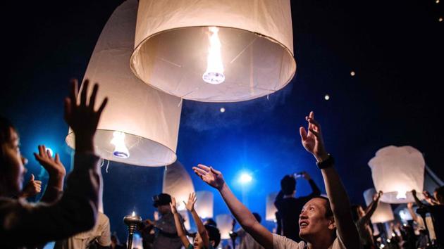 People releases lanterns into the air as they celebrate the Yee Peng festival. The festivals are thought to carry away bad luck and usher in good fortune. (Roberto Schmidt / AFP)
