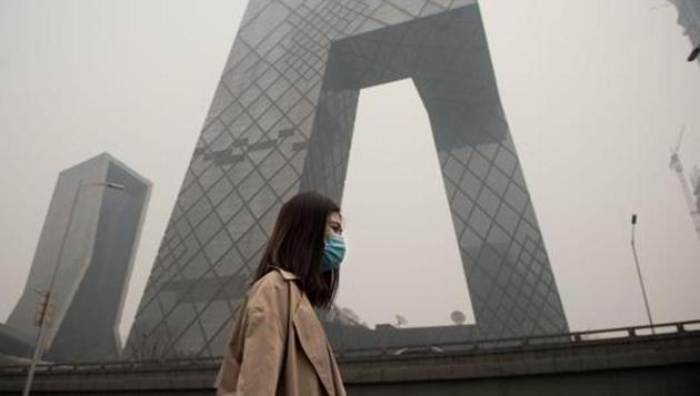 A woman wearing a protective pollution mask walks on a street in Beijing in March. (AFP File) A woman wearing a protective pollution mask walks on a street in Beijing in March. (AFP File)