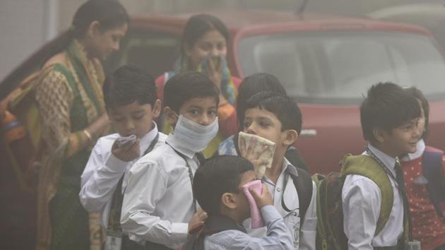 Students wait for school bus on Wednesday morning as thick haze engulfs Delhi’s Mayur Vihar.(Sushil Kumar/HT PHOTO)