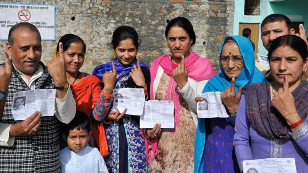 A family showing their ink marks after casting their vote in Arki constituency’s Kotli village on Thursday. (Ravi Kumar/HT)