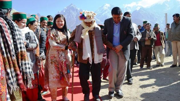 Poll officials gave Negi a red carpet welcome with a traditional band playing in the background as he arrived at the polling booth, walking stick in hand.(HT Photo)
