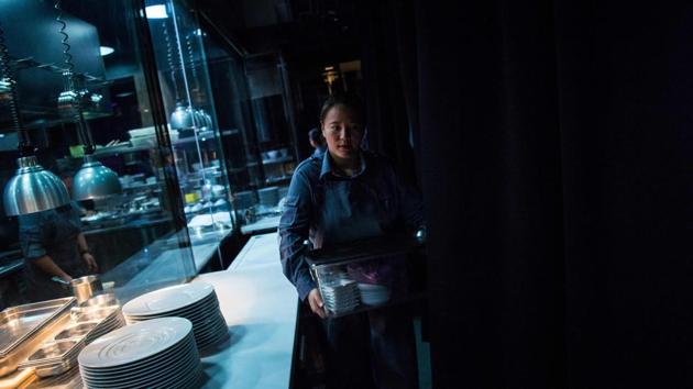 A staff member seen mid-service inside the kitchen at Ultraviolet in Shanghai. Each group dines on 22 courses --served in an atmosphere tailored to that dish and created by video and other images projected on the walls, pumped-in aromas, and its own soundtrack. (Chandan Khanna / AFP) 