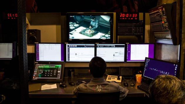 A staff member pores over monitors keeping time with the kitchen as well as the audio, visual and extra sensory elements of the meal in progress at Ultraviolet restaurant’s nightly service. (Chandan Khanna / AFP) 