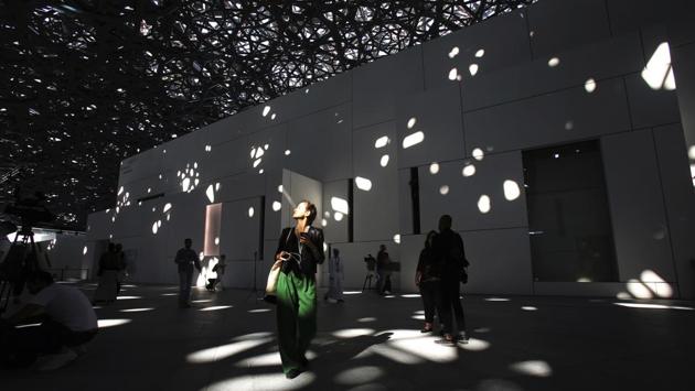 A journalist walks under light filtering through the dome at the Louvre Abu Dhabi. France’s Pritzker prize-winning architect Jean Nouvel, conjures up the image of an Arab medina with a silver-toned dome and honeycombed patterns which appear to float over the white galleries. To reach the ground, each ray of light crosses eight layers of perforations, creating a constantly shifting pattern that mimics the shadows cast by palm trees or the roof of a traditional Arab market. (Kamran Jebreili / AP)