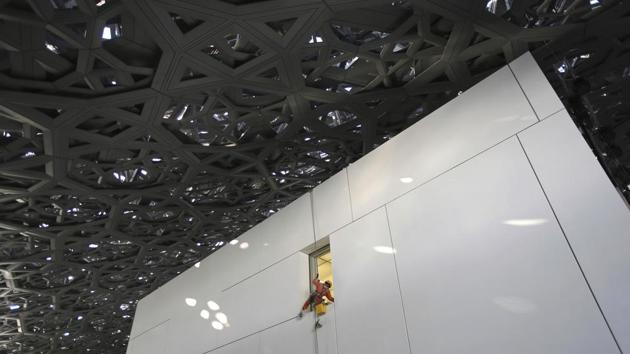 A worker cleans a window under the dome of the Louvre Abu Dhabi. During construction, the project faced criticism over labourer work conditions, including low pay and long hours in the heat. Multiple deaths were reported, according to Abu Dhabi authorities. Hundreds working on projects on the island, including the Louvre, were deported or lost work visas for launching strikes, according to a 2015 Human Rights Watch report. (Kamran Jebreili / AP)