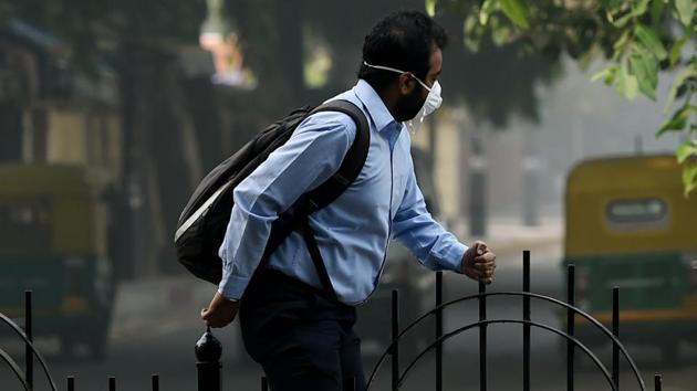 A man wears a mask to protect himself from pollution as he crosses a divider on a road in Delhi on November 9. (AFP) A man wears a mask to protect himself from pollution as he crosses a divider on a road in Delhi on November 9. (AFP)