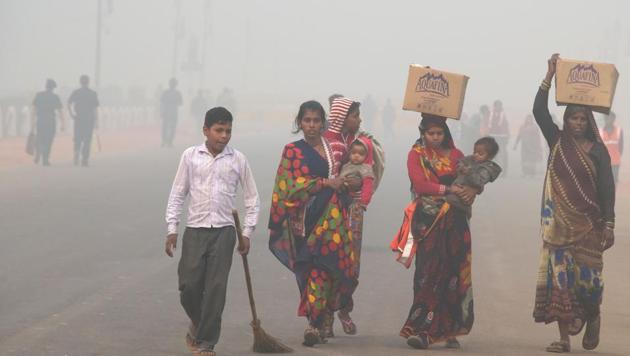Residents walk along a road amid heavy smog in New Delhi on November 9.(AFP)