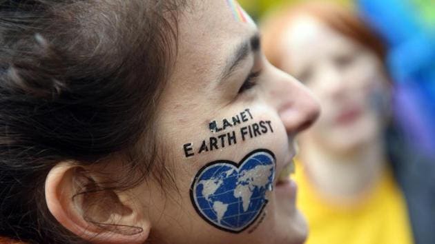 A female protester wears the slogan --Planet Earth First-- on her face, at a Greenpeace demonstration under the motto “Kids for Earth” in Bonn on November 6, 2017. The 23rd UN Climate Conference (COP23) is the first such gathering since President Donald Trump announced he would extricate the US from the 2015 Paris Agreement aimed at curbing global warming. (Henning Kaiser / AFP) 