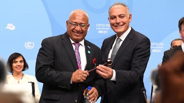 Salaheddine Mezouar (R), Moroccan Foreign Minister and President of COP22, hands over a symbolic hammer to Frank Bainimarama, Prime Minister of Fiji and President of the COP23, during the opening session. Following a cascade of grim reports on the gathering pace of global warming, Fiji’s Prime Minister made an open plea to the world for ‘urgent action’ on climate change.  (Patrik Stollarz / AFP) 