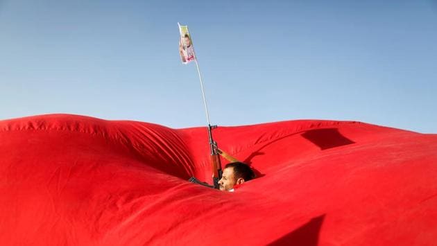 A Houthi follower emerges from a gap in a flag as he attends a rally to show support to Palestinians in Sanaa, Yemen on November 6, 2017. (Khaled Abdullah / REUTERS) A Houthi follower emerges from a gap in a flag as he attends a rally to show support to Palestinians in Sanaa, Yemen on November 6, 2017. (Khaled Abdullah / REUTERS)