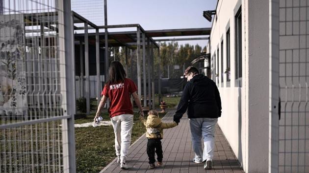 An educator (L) holds the hand of a child outside the Biobab nursery at Bollate Penitentiary. Opened as part of facilities to improve the wellbeing of staff, the creche was initially little used with prison employees reluctant to switch from their established childcare arrangements. Opening it up to the public brought an unexpectedly enthusiastic response from the prison’s neighbours. (Marco Bertorello / AFP) An educator (L) holds the hand of a child outside the Biobab nursery at Bollate Penitentiary. Opened as part of facilities to improve the wellbeing of staff, the creche was initially little used with prison employees reluctant to switch from their established childcare arrangements. Opening it up to the public brought an unexpectedly enthusiastic response from the prison’s neighbours. (Marco Bertorello / AFP)