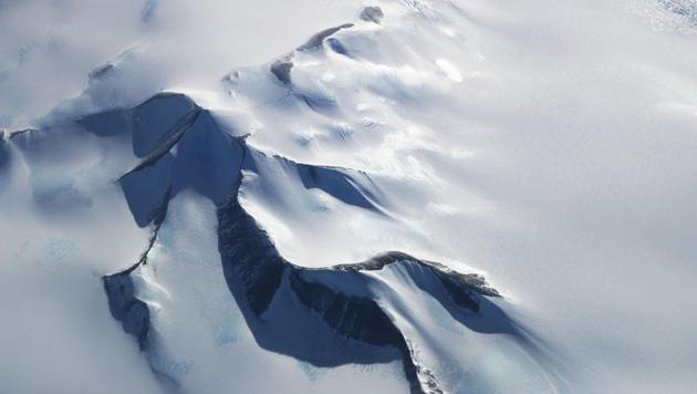 Mountain’s peek through land ice seen from NASA’s Operation IceBridge research aircraft in the Antarctic Peninsula region on October 31, 2017, above Antarctica. Operation IceBridge has been studying how polar ice has evolved over the past eight years and is currently flying a set of nine-hour research flights over West Antarctica to monitor ice loss aboard a retrofitted 1966 Lockheed P-3 aircraft. (Mario Tama / Getty Images / AFP)