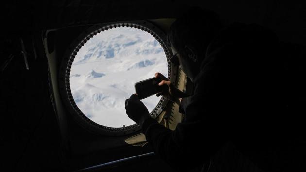 Operation IceBridge project scientist Nathan Kurtz takes photographs from high above in the Antarctic Peninsula region, on November 3, 2017. These flights will provide a yearly, multi-instrument look at the behaviour of the rapidly changing features of the Greenland and Antarctic ice. (Mario Tama / Getty Images / AFP)