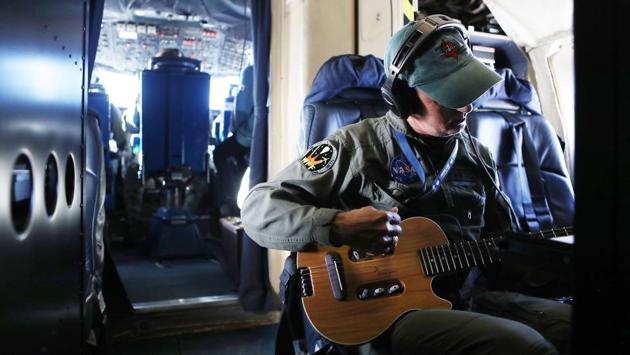 NASA’s Operation IceBridge mission scientist John Sonntag plays his guitar, following a long science flight, on November 3, 2017 above Antarctica. (Mario Tama / Getty Images / AFP)