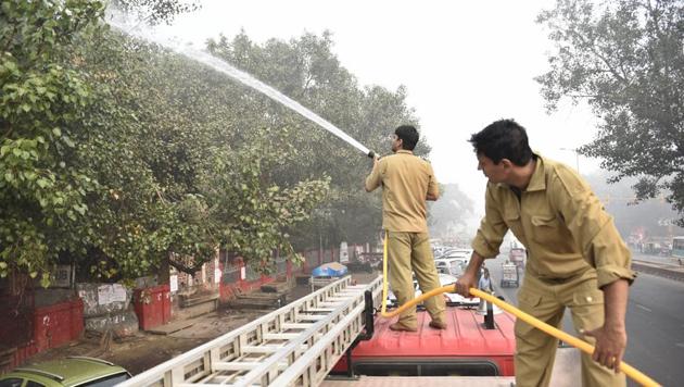 Delhi Fire Services personnel sprinkle water on trees to settle the dust as part of pollution-control measures in New Delhi. (Sanchit Khanna / HT Photo) Delhi Fire Services personnel sprinkle water on trees to settle the dust as part of pollution-control measures in New Delhi. (Sanchit Khanna / HT Photo)