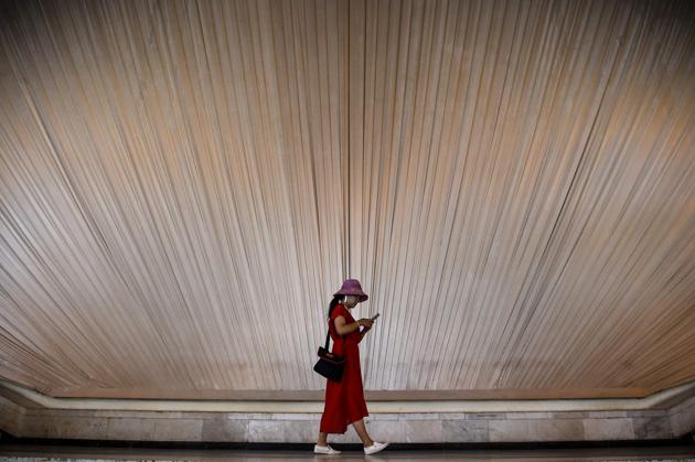 A woman looks at her phone as she walks inside an exhibition centre in Shanghai on September 8. (AFP File Photo) A woman looks at her phone as she walks inside an exhibition centre in Shanghai on September 8. (AFP File Photo)
