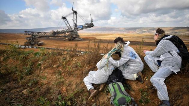 Activists look on as policemen prevent other environmentalists from marching further after they entered the Hambach lignite open pit mine near Elsdorf, western Germany, on November 5, 2017, during a protest against fossil-based energies ahead of the UN Climate Change Conference (COP23). (Sascha Schuermann / AFP) Activists look on as policemen prevent other environmentalists from marching further after they entered the Hambach lignite open pit mine near Elsdorf, western Germany, on November 5, 2017, during a protest against fossil-based energies ahead of the UN Climate Change Conference (COP23). (Sascha Schuermann / AFP)
