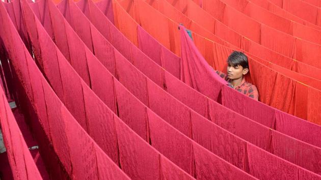 An artisan dries stoles after dyeing them at workshop in Amritsar, Punjab on November 5, 2017. (Narinder Nanu / AFP)