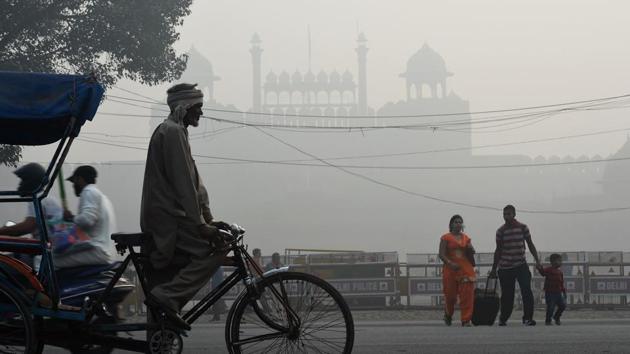 An Indian family crosses a road amid heavy smog in front of the Red Fort in New Delhi on November 10, 2017. Large swathes of India's northern states remained under dense smog that has shut hundreds of thousands of schools, disrupted air and railway services and forced residents to stay indoors.(AFP)