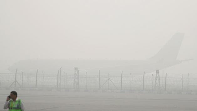 An airport staff member speaks on his mobile phone as a silhouette of a plane can be barely seen amid the smog in New Delhi, on November 8, 2017.(Reuters Photo) An airport staff member speaks on his mobile phone as a silhouette of a plane can be barely seen amid the smog in New Delhi, on November 8, 2017.(Reuters Photo)