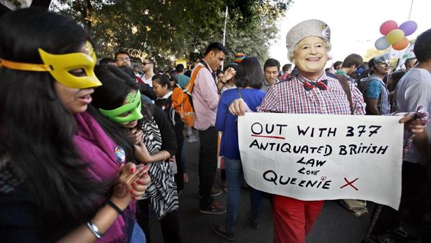 A participant holds a placard and wears a mask bearing the image of Queen Elizabeth II during the Pride march in 2014. India never criminalised homosexuality and gay sex in the past. It was the English who criminalised it but India has failed to strike off Section 377 from its constitution.  (Arun Sharma / HT Photo) 