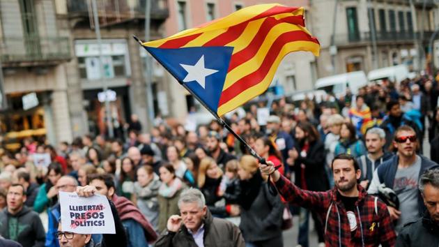 A man holds a Catalan pro-independence 'Estelada' flag in Barcelona on November 8, 2017 during a regionwide strike called by a pro-independence union. (AFP) A man holds a Catalan pro-independence 'Estelada' flag in Barcelona on November 8, 2017 during a regionwide strike called by a pro-independence union. (AFP)