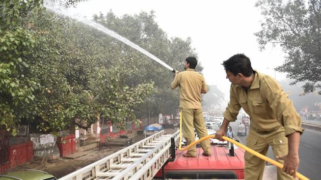 Delhi Fire Services personnel sprinkle water on trees to settle dust: one of the several measures taken to control severe air pollution in the city.(Sanchit Khanna/ HT Photo)