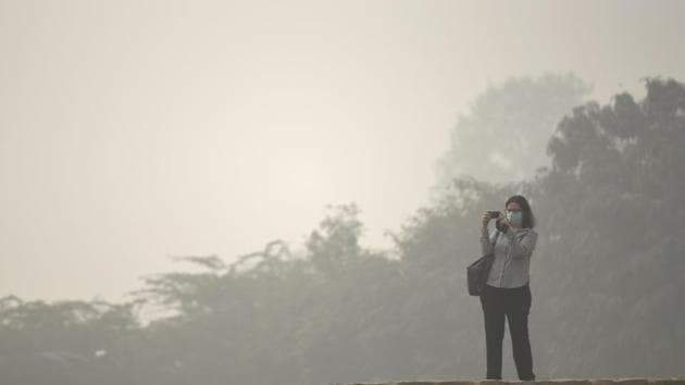 A tourist at Qutub Minar wears a mask as a thick blanket of haze engulfs New Delhi on Sunday. (Sanchit Khanna/HT PHOTO) A tourist at Qutub Minar wears a mask as a thick blanket of haze engulfs New Delhi on Sunday. (Sanchit Khanna/HT PHOTO)