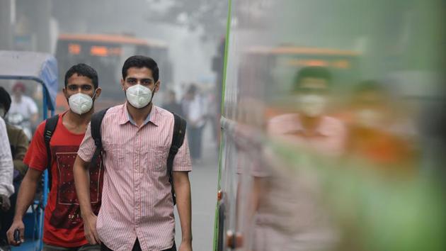 People wear masks as they walk along a road amid heavy smog in New Delhi on November 9, 2017. The poor air quality triggered several emergency measures in India’s national capital.(AFP Photo)