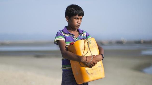 In this Nov. 4, 2017, photo, Rohingya Muslim Nabi Hussain, 13, poses for a portrait with the yellow plastic drum he used as a flotation device while crossing the Naf river in Shar Porir Dwip, south Cox's Bazar, Bangladesh. )(AP)