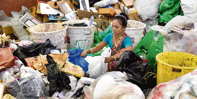 A waste-picker surrounded by heaps of garbage at Baner waste sorting shed on Tuesday.(SANKET WANKHADE/HT PHOTO)