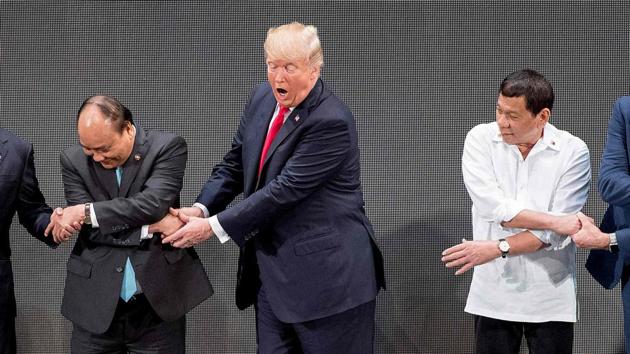 (L-R) Vietnamese Prime Minister Nguyen Xuan Phuc, US President Donald Trump and Philippine President Rodrigo Duterte join hands for the family photo during the 31st Association of South East Asian Nations (ASEAN) Summit in Manila. World leaders descended into the Philippines capital for two days of summits. (Jim Watson / AFP)