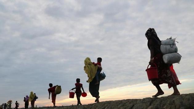 Rohingya refugees walk after crossing the Naf River with an improvised raft to reach to Teknaf in Bangladesh.(REUTERS)
