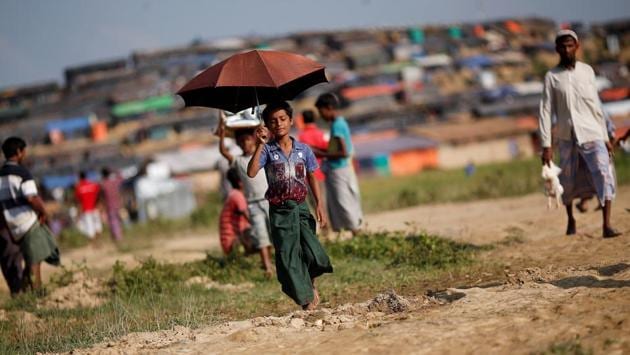 Nur Hafes, 12, a Rohingya refugee, carries an umbrella as shade from the sun at Palong Khali refugee camp, near Cox’s Bazar, Bangladesh. Twelve-year-old Nur would rather be in school or playing football with friends back home in Myanmar. His family displaced; Nur is now the sole breadwinner for seven younger siblings and his mother taking refuge in Bangladesh. (Adnan Abidi / REUTERS) Nur Hafes, 12, a Rohingya refugee, carries an umbrella as shade from the sun at Palong Khali refugee camp, near Cox’s Bazar, Bangladesh. Twelve-year-old Nur would rather be in school or playing football with friends back home in Myanmar. His family displaced; Nur is now the sole breadwinner for seven younger siblings and his mother taking refuge in Bangladesh. (Adnan Abidi / REUTERS)