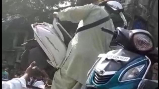 A video grab of the man taking his scooter down from the police towing van. (HT) A video grab of the man taking his scooter down from the police towing van. (HT)
