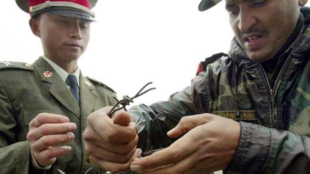 File photo taken on July 5, 2006 shows a Chinese soldier (left) and an Indian soldier placing a barbed wire fence following a meeting of military representatives at the Nathu La border crossing in India's northeastern Sikkim state. (AFP) File photo taken on July 5, 2006 shows a Chinese soldier (left) and an Indian soldier placing a barbed wire fence following a meeting of military representatives at the Nathu La border crossing in India's northeastern Sikkim state. (AFP)
