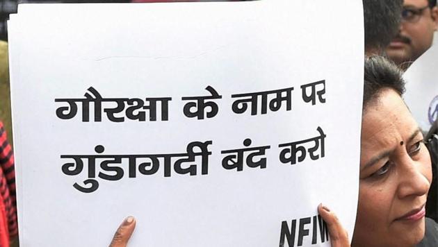 An NGO activist displays a placard during a protest demanding justice for the mob lynching victim Umar Khan , at Bikaner House in New Delhi on Wednesday. (PTI)