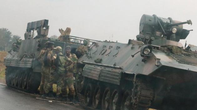 Soldiers stand beside military vehicles just outside Harare, Zimbabwe, on Tuesday.(Reuters Photo)