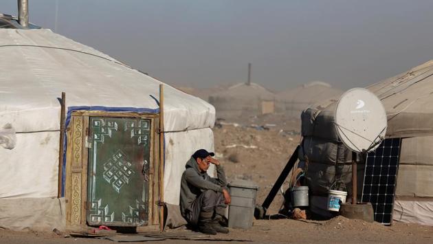 A man sits at the Tsagaan Khan rest spot for truck drivers near the China-Mogolia border. Whatever the fate of the railroad, those plying the roads have little choice but to keep driving given the lack of opportunities in a country strapped by austerity measures linked to the IMF bailout. (B. Rentsendorj / Reuters)