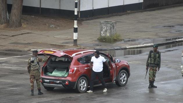 Armed soldiers search a vehicle on the road leading to President Mugabe’s office. The military today guaranteed the judiciary its independence, saying it will protect the civil service and urged other security services to “cooperate for the good of our country,” warning that “any provocation will be met with an appropriate response.” (Tsvangirayi Mukwazhi / AP) 