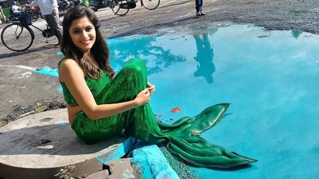 A Bengaluru-based artist has turned a pothole near Cubbon Park Junction into an art installation, with a woman dressed as a mermaid protesting the poor condition of roads in the city that have led to fatal accidents. (Courtesy: Baadal Nanjundaswamy’s Facebook page)