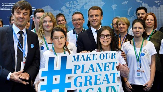 French President Emmanuel Macron (C) and French Minister for the Ecological and Inclusive Transition Nicolas Hulot (L) pose with youth as they visit the French stand during the UN conference on climate change (COP23) on November 15, 2017 in Bonn, western Germany.(AFP)