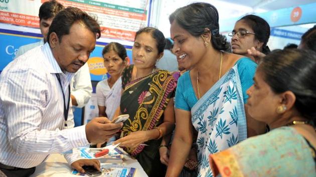 A bank employee (L) explains to visitors about account transactions from a mobile phone during a Digi Dhan Mela, held to promote digital payment, in Hyderabad on January 18, 2017.(AFP file photo) A bank employee (L) explains to visitors about account transactions from a mobile phone during a Digi Dhan Mela, held to promote digital payment, in Hyderabad on January 18, 2017.(AFP file photo)