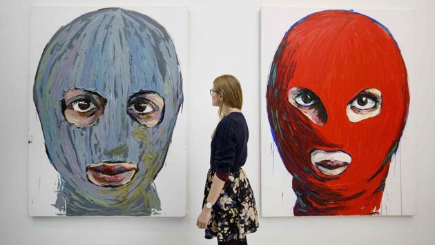 A gallery assistant poses with ‘Pussy Icons’ by contemporary artist Lusine Djanyan. The 2012 stunt resulted in two members serving two years in penal colonies, gaining them notoriety, the support of Western politicians and mega-artists like Madonna. Visitors to the exhibition will don balaclavas similar to the group’s members and be preached at by priests. (Tolga Akmen / AFP)