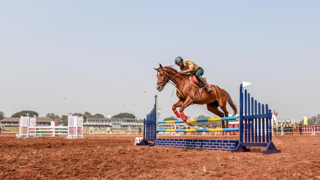 A participant makes his horse jump over a hurdle during the Southern Star Horse show at Pune Race Course on Thursday. (Sanket Wankhade/HT PHOTO) 