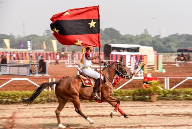 A cadet hoisting the flag while riding a horse to honour the chief guests at the Southern Star Horse Show-2017 at Pune Race Course on Thursday. (Sanket Wankhade/HT PHOTO) 