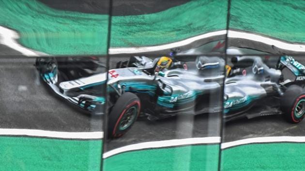 Mercedes British driver Lewis Hamilton is reflected on windows as he powers through a Brazilian F1 Grand Prix practice session in Sao Paulo, Brazil, on November 11, 2017. Hamilton tweeted that members of his Mercedes team had guns held to their heads as they were robbed leaving the Interlagos circuit on Friday. (Nelson Almeida / AFP) 