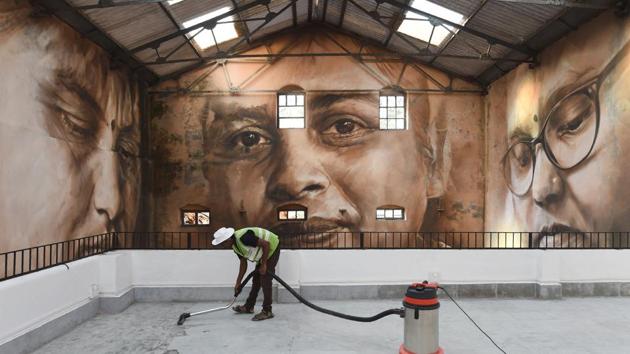 A worker cleans the viewing area in front of a photo mural at Sassoon Dock. Thirty artists from around the world have given the bustling 142-year-old Sassoon Docks, a colourful makeover as part of the 2017 edition of the St+art Urban Art Festival in Mumbai. (Indranil Mukherjee / AFP) A worker cleans the viewing area in front of a photo mural at Sassoon Dock. Thirty artists from around the world have given the bustling 142-year-old Sassoon Docks, a colourful makeover as part of the 2017 edition of the St+art Urban Art Festival in Mumbai. (Indranil Mukherjee / AFP)